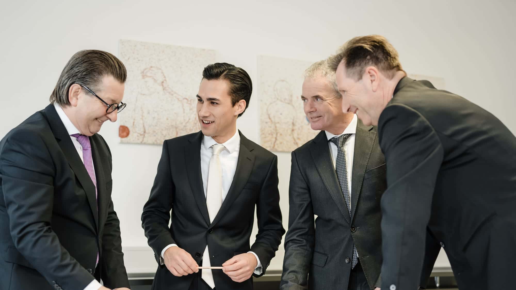 Besprechung im ALPHAUS-Büro — Kollegen arbeiten gemeinsam über Plänen