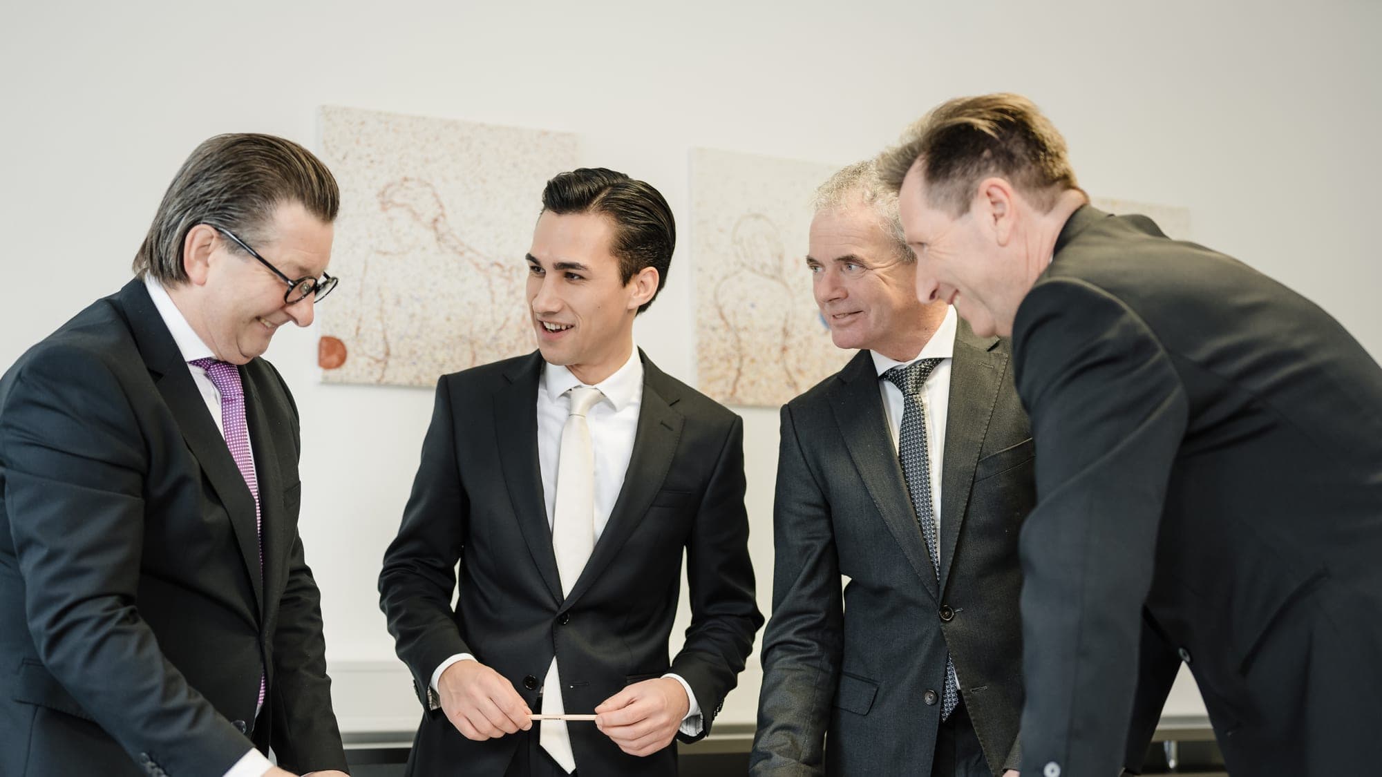 Besprechung im ALPHAUS-Büro — Kollegen arbeiten gemeinsam über Plänen